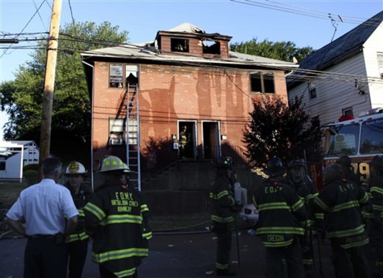 ** ADDS POSSIBLE MURDER-SUICIDE ** Firefighters and other first responders work on the site of a fatal fire in New York, Thursday, July 22, 2010. The early morning fire in a house on New York City's Staten Island has killed five people. The deaths of a mother and four children in a torched New York city apartment were being investigated Thursday as a possible murder-suicide committed by one of the children, a troubled teenager with a history of setting fires, police said. (AP Photo/Seth Wenig)